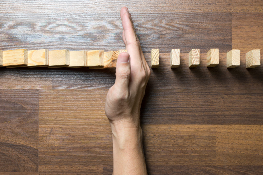 Managing Risks in the Software Audit Process, exemplified by stopping falling dominoes. 